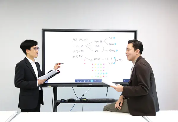 신한투자증권 오강호 수석연구원(오른쪽)이 2022년 신규 입사직원 노승현 주임을 코칭하고 있다.