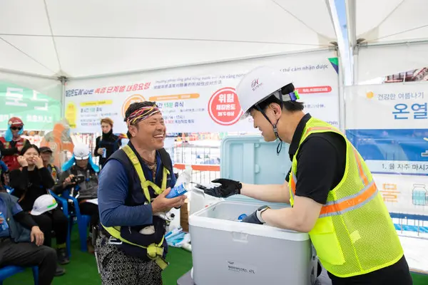 황준하 CSO(사진 오른쪽)가 현장 근로자에게 얼음물과 이온음료를 건네고 있다.(사진 현대건설)