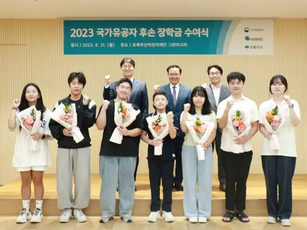 사진 위쪽 왼쪽부터 우미희망재단 이춘석 사무국장, 국가보훈부 복지정책과 김석기 과장, 초록우산어린이재단 박수봉 본부장과 장학금을 받은 국가유공자 후손 학생들이 기념촬영을 하고 있다. (사진. 우미희망재단)