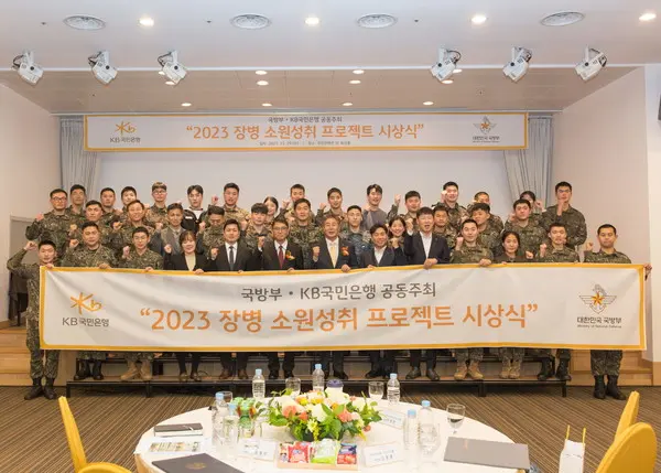 29일 서울시 용산구에 위치한 국방컨벤션에서 열린 ‘2023 장병소원성취 프로젝트’ 시상식에서 윤봉희 국방부 정책기획관(맨 앞 줄 좌측 6번째), 김동록 KB국민은행 기관고객그룹 대표(맨 앞 줄 좌측 7번째) 및 관계자들이 수상 장병들과 기념사진을 촬영하고 있다.