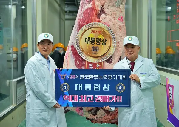 이영상 동원홈푸드 축육부문 대표(왼쪽)와 이재윤 한국종축개량협회 회장(오른쪽)이 ‘제26회 전국한우능력평가대회’에서 대통령상 한우를 낙찰받고 기념 촬영을 하고 있다