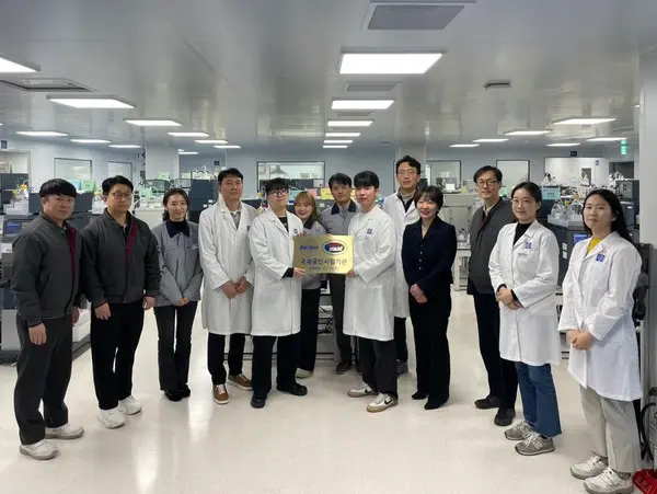 종근당 천안공장에서 황주영 이사(우측 세번째)와 임나영 이사(우측 네번째)를 비롯한 임직원들이 국제공인시험기관 인증마크를 들고 기념 촬영을 하고 있다.