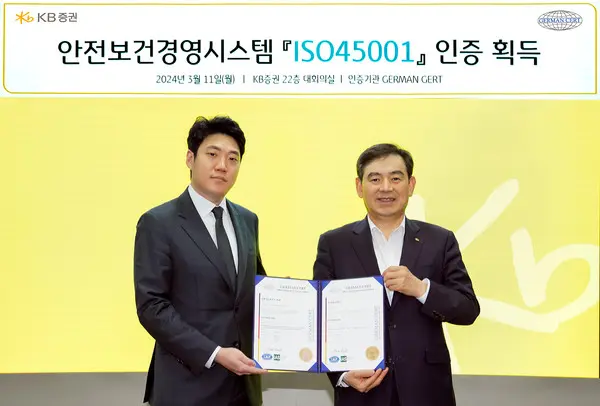 지난 11일(월) KB증권 김성현 대표이사(오른쪽)와 ‘국제표준화기구’(ISO) 인증기관인 저먼서트인증원 안상현 대표이사(왼쪽)가 안전보건경영시스템 ‘ISO45001’ 인증 획득을 기념하여 KB증권 본사에서 사진 촬영을 하고 있다.