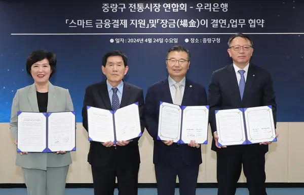 우리은행이 지난 24일 서울 중랑구청에서 중랑구 전통시장 연합회와 스마트 금융결제 지원 과 ‘장금(場金)이 결연’ 업무협약을 체결했다. 왼쪽부터 정현옥 우리은행 금융소비자보호그룹 부행장, 한대섭 중랑구 전통시장 연합회 회장, 류경기 중랑구청 구청장, 정진완 우리은행 중소기업그룹 부행장이다. [출처: 우리은행]