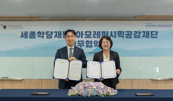 아모레퍼시픽공감재단 이상목 이사장(왼쪽)과 세종학당재단 이혜영 이사장이 업무협약 체결 후 기념촬영을 하고 있다. (사진. 아모레퍼시픽공감재단)