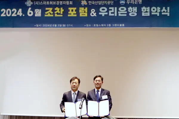 우리은행은 3일 경기 안산시 호텔스퀘어에서 스마트허브경영자협회와 업무협약을 체결했다. 협약식에 참석한 기동호 우리은행 기업투자금융부문 부문장(오른쪽)과 최철호 스마트허브경영자협회 회장이 협약서를 들고 있다. [출처: 우리은행]