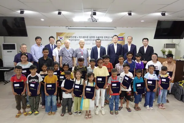 KB국민은행과 헤브론의료원이 지난 12일 캄보디아 수도 프놈펜 소재 헤브론의료원에서 심장병 수술아동 장학금 수여식을 열었다. 뒷줄 왼쪽 4번째부터 배기안 헤브론병원장, 김우정 헤브론의료원장, 옴 쌈은 KB프라삭은행장, 김현종 KB프라삭은행 부행장 등이 수여식에 참석했다. [출처: KB국민은행]