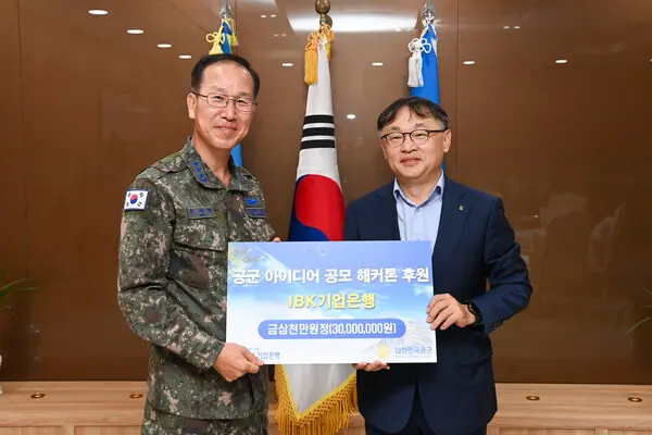 유일광 IBK기업은행 개인고객그룹 부행장(오른쪽)이 지난 24일 충남 계룡시 공군본부에서 손석락 공군참모차장 중장에게 제6회 공군 해커톤 행사 후원금을 전달했다. [출처: IBK기업은행]