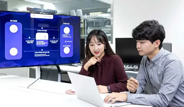 SK텔레콤과 삼성전자 연구원이 AI 기반 5G 기지국 품질 최적화 기술 실증에 대해 논의하는 모습