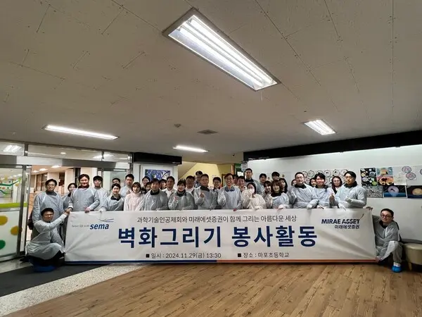 지난 29일 미래에셋증권 및 과학기술공제회 임직원이 서울 마포구에 위치한 마포초등학교를 방문해 실내 계단 벽화 그리기 봉사활동을 마치고 기념촬영을 하고 있다 (사진제공: 미래에셋증권)