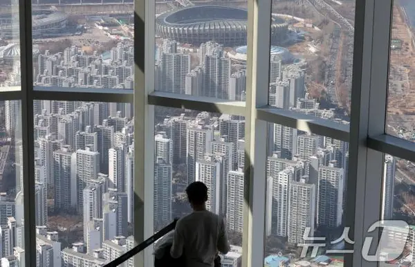 서울 송파구 롯데월드타워 서울스카이를 찾은 관람객이 서울 송파구 잠실 아파트단지를 바라보고 있다. 2025.2.13/뉴스1 ⓒ News1 박세연 기자