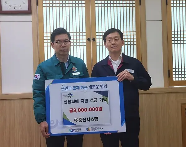 중산시스템 이관석 전무(오른쪽)가 김광열 영덕군수를 만나 성금을 전달하고 있다. (중산시스템 제공)