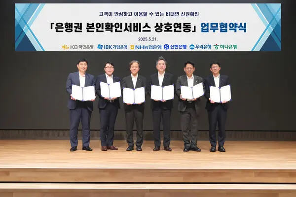 하나은행은 21일 국내 주요 은행(국민∙농협∙신한∙우리∙IBK)과 함께 은행권 공동 본인확인서비스 추진 및 마케팅을 위한 MOU를 체결했다고 밝혔다. 이날 협약식에 참석한 은행 주요 관계자들이 기념촬영을 하고있다.