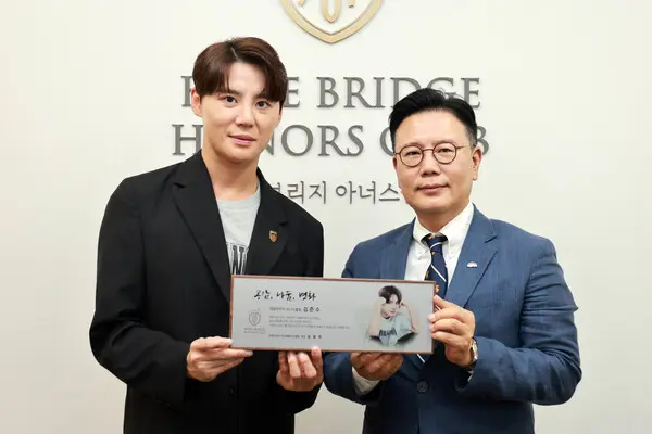 희망브리지 전국재해구호협회 신훈 사무총장(오른쪽)과 가수 겸 뮤지컬 배우 김준수가 9일 오후 서울 마포구 희망브리지에서 희망브리지 아너스클럽 회원 위촉을 기념해 사진을 촬영하고 있다. (사진제공=희망브리지)