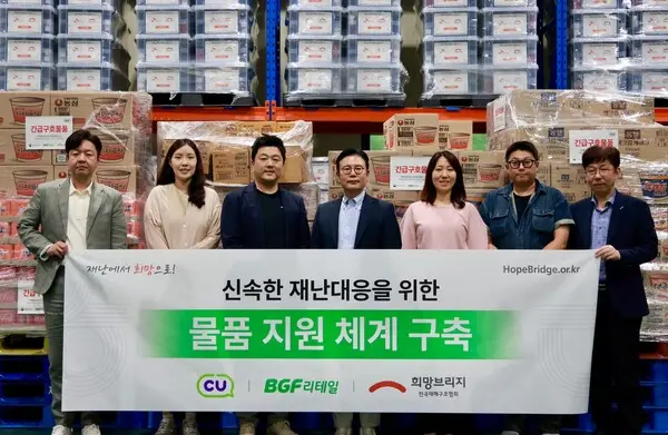 희망브리지와 BGF리테일 관계자들이 재난 발생 시 신속한 이재민 지원을 위한 구호물품 비축 체계 구축을 기념하며 파주 재해구호물류센터에서 기념촬영을 하고 있다(사진제공=희망브리지)