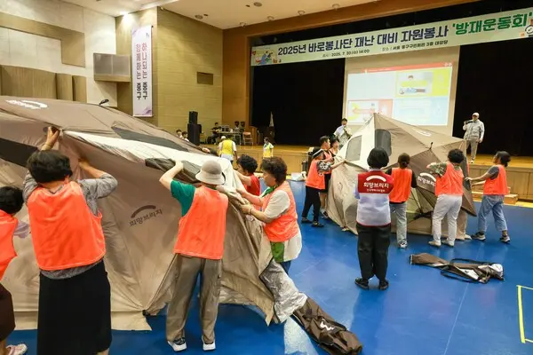 지난 30일 서울 중구 구민회관에서 열린 2025년 바로봉사단 재난 대비 자원봉사 방재운동회에서 참가자들이 희망브리지의 이재민 대피소 쉘터를 설치하고 있다. (사진=희망브리지)