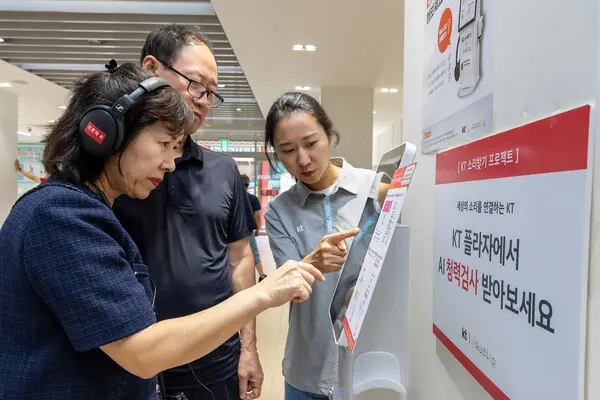 KT플라자에 방문한 고객이 KT 직원으로부터 AI 청력검사 키오스크의 사용법에 대한 설명을 듣고 있다. (제공 KT)