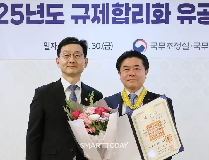 박동민 대항상공회의소 전무(오른쪽)가 30일 서울 종로구 정부서울청사에서 열린 규제합리화 유공 정부포상에서 국민훈장 동백장을 수훈한 뒤 윤창렬 국무조정실장과 사진촬영을 하고 있다. (사진제공=대한상공회의소)