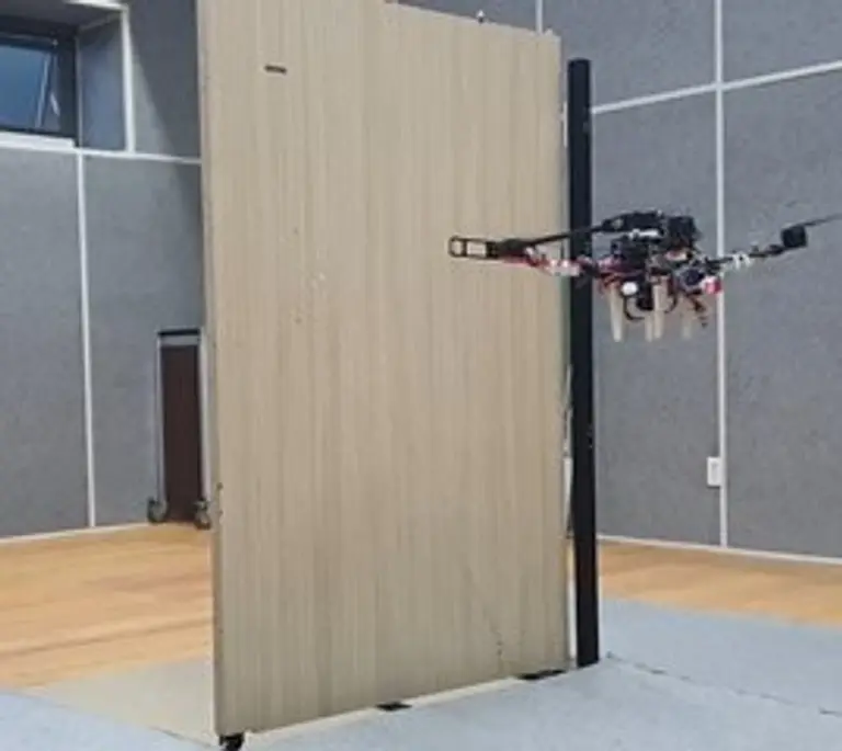 ▲서울대학교 공과대학 김현진 교수 연구팀이 개발한 비행형 머니퓰레이터가 로봇 팔을 이용해 문을 열고 있다.