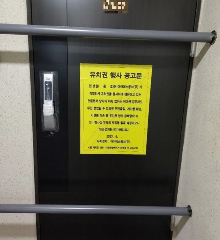 부산 영도구 동삼동 ‘오션라이프 에일린의 뜰 조합원 소유 아파트 현관문에 유치권 행사 문구가 붙어 있다.(사진. 조합원 제공)