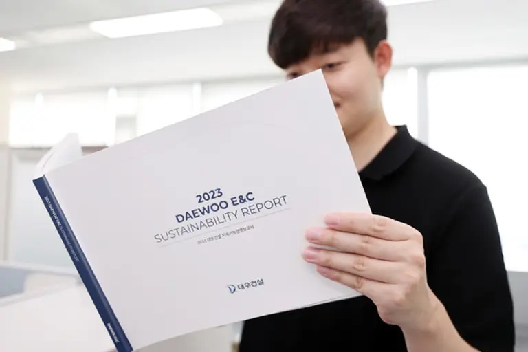 대우건설 2023 지속가능경영보고서를 보고 있는 직원(사진. 대우건설)