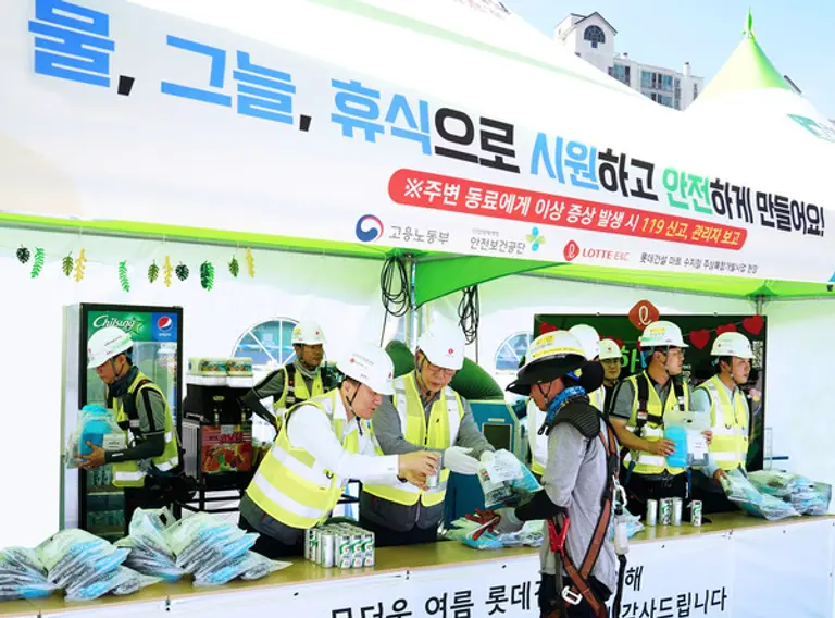 롯데건설 박현철 부회장(앞줄 왼쪽 두번째)이 현장 근로자들에게 혹서기 물품을 전달하고 있다. (사진. 롯데건설)