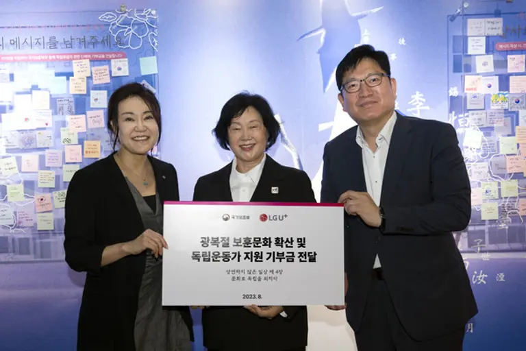 사진은 일상비일상의틈byU+에서 열린 기부금전달 약정식에서 (왼쪽부터)정혜윤 LG유플러스 마케팅그룹장, 문영숙 (사)독립운동가 최재영 기념사업회 이사장, 오진영 국가보훈부 보훈정책실장이 기념촬영을 하고 고객 참여 메시지를 살펴보고 있는 모습. (사진=LG유플러스)
