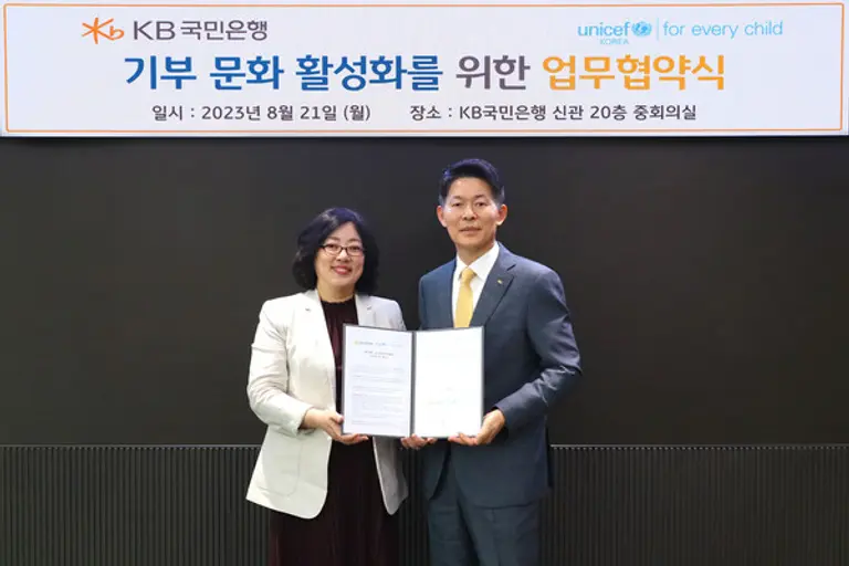 21일 서울 영등포구 KB국민은행 신관에서 진행된 협약식에서 박형지 유니세프한국위원회 사무총장(좌측)과 최재영 KB국민은행 WM고객그룹 부행장이 기념 촬영을 하고 있다. (사진=KB국민은행)