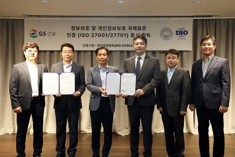 12일 GS건설 본사에서 진행된 ‘정보보호경영시스템 및 개인정보보호 인증 획득’ 행사. GS건설 김종대 마케팅담당, 박준규 정보보안담장, 김영신 CTO, BSI코리아 임성환 대표이사, GS건설 김석환 플랫폼담당, 이왕제 DX담당(왼쪽부터)이 기념촬영을 하고 있다. (사진제공. GS건설)