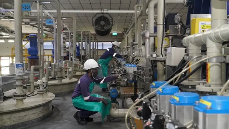 테스의 싱가포르 사업장에서 작업자들이 폐배터리 리사이클링 설비를 점검하는 모습 (사진제공. SK에코플랜트)