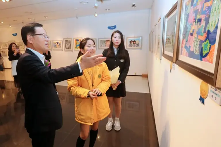 조병규 은행장이 ‘제26회 우리은행 우리미술대회’ 수상자로부터 수상 작품에 대해 설명을 듣고 있다.