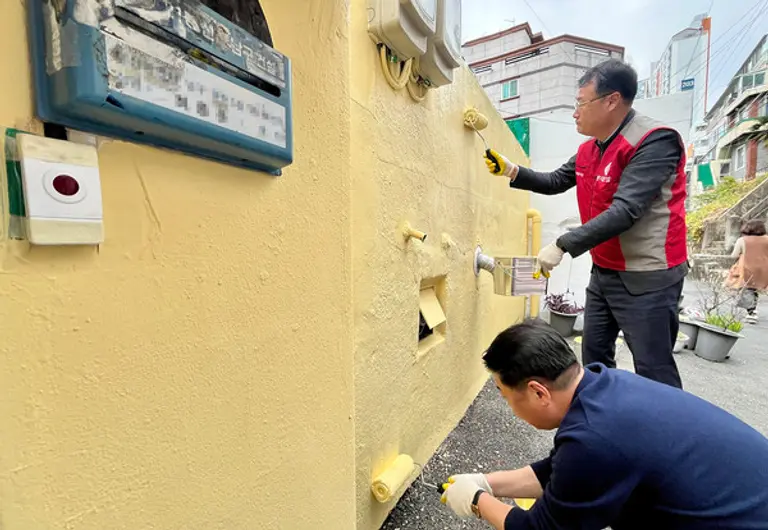 롯데건설 윤수준 영남지사장(위)과 오은택 남구청장이 외벽 도장 보수를 하고 있다. (사진. 롯데건설)
