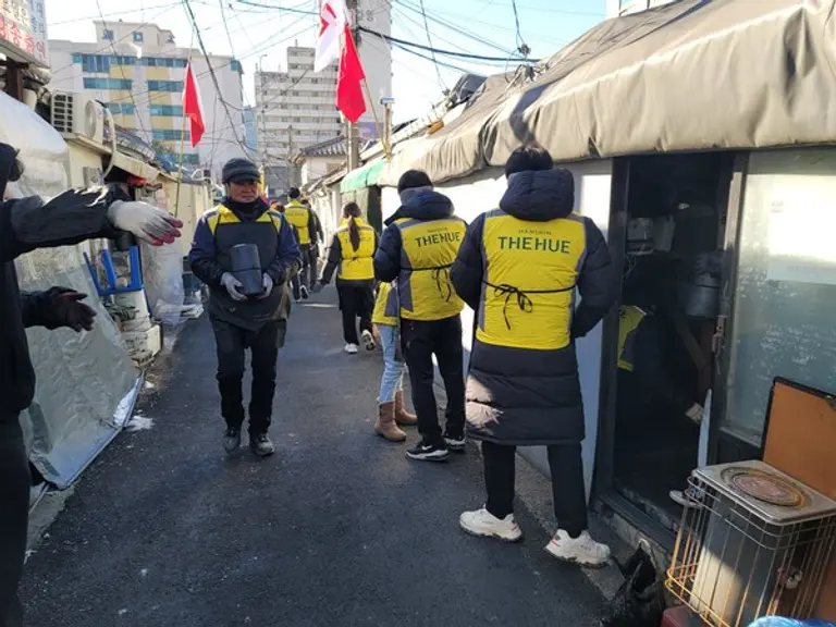 한신공영(주) 선홍규 대표(왼쪽)가 임지원들과 함께 연탄을 나르고 있다. (사진제공. 한신공영)