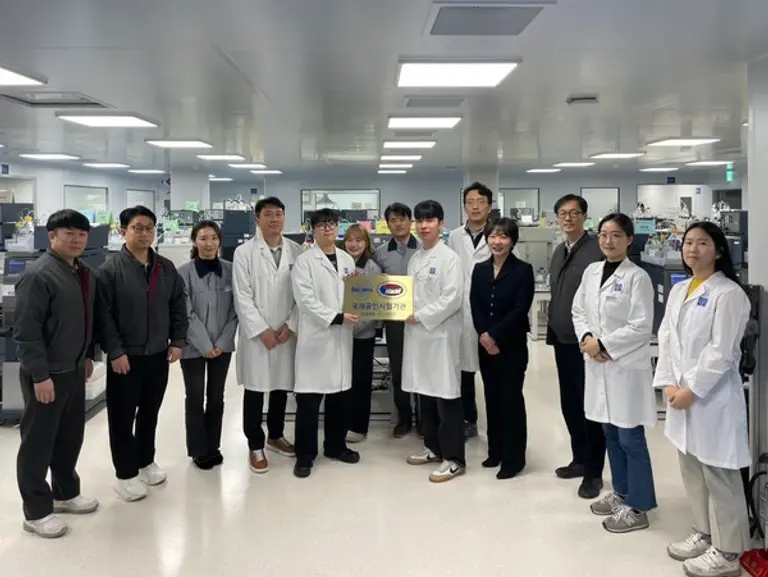 종근당 천안공장에서 황주영 이사(우측 세번째)와 임나영 이사(우측 네번째)를 비롯한 임직원들이 국제공인시험기관 인증마크를 들고 기념 촬영을 하고 있다.