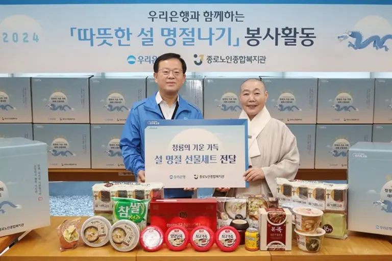 조병규 우리은행장(왼쪽)이 7일 정관 종로노인종합복지관 관장에게 설 명절 선물세트를 전달했다. 명절 먹거리 선물은 홀로 지내는 어르신 250분에게 전해졌다. [출처: 우리은행]