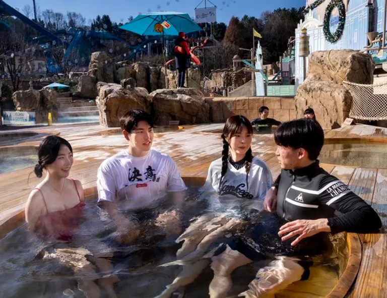 거대한 해골 포토스팟 아래 뜨끈하게 노천 스파를 즐길 수 있는 캐리비안 베이 야외 어드벤처풀 지역에서 편백나무(히노끼) 노천탕을 즐기고 있는 모습