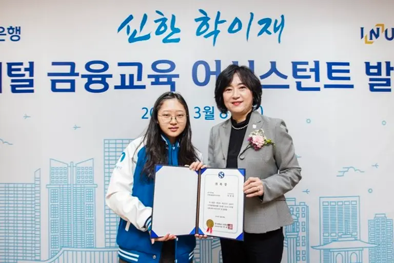 지난 8일 인천시 남동구 소재 금융소비자 교육센터 ‘신한 학이재’에서 ‘신한 학이재 디지털 금융교육 어시스턴트’ 발대식을 개최하고 신한은행 소비자보호그룹 박현주 부행장(오른쪽)과 어시스턴트 대표 학생이 기념 촬영 하고 있는 모습.