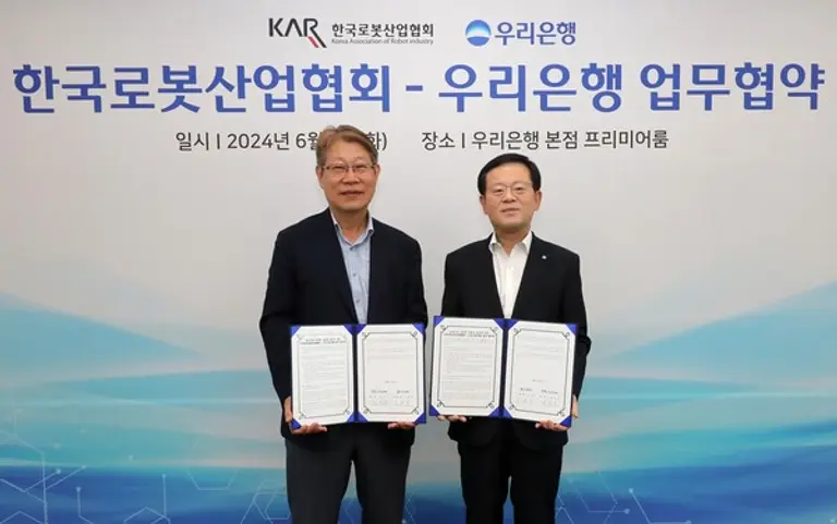 조병규 우리은행장(오른쪽)과 김진오 한국로봇산업협회 회장이 지난 4일 서울 중구 우리은행 본점에서 한국로봇산업협회와 업무협약을 체결했다. [출처: 우리은행]