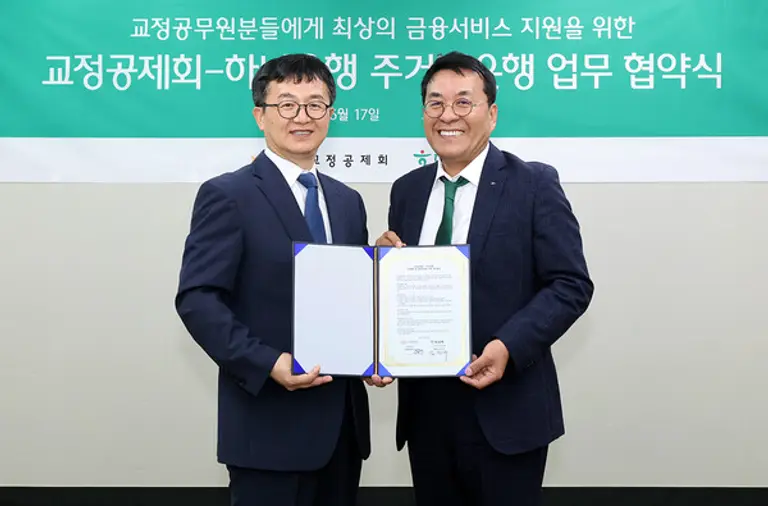 하나은행은 지난 17일 서울 강남구 교정공제회에서 교정공제회와 상생협력 및 동반성장을 위한 주거래은행 업무협약을 체결했다. 김진우 하나은행 강남영업본부 본부장(오른쪽)과 장종선 교정공제회 이사장이 협약서를 들고 있다. [출처: 하나은행]