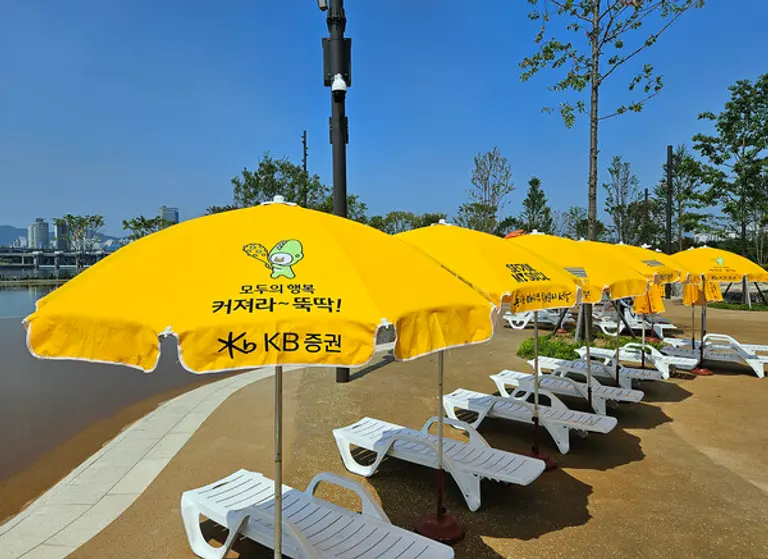 KB증권이 서울시 미래한강본부와 협력하여 파라솔 150개를 설치했다.