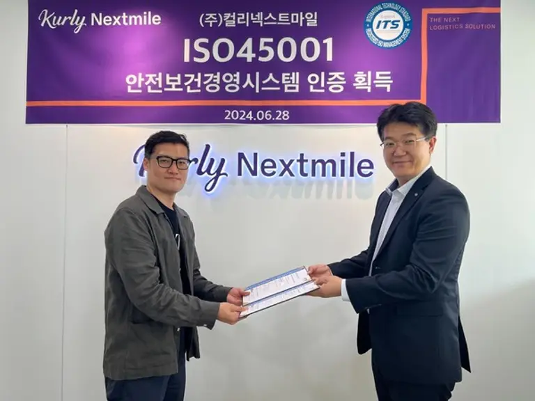 송승환(왼쪽) 컬리넥스트마일 대표이사가 컬리넥스트마일 본사에서 박준영 ITS 인증원장에게 ISO45001 인증서를 수여받고 있다.