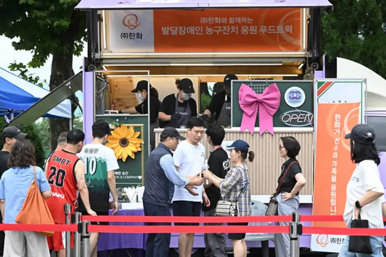 한화 임직원들이 ‘제 22회 서울특별시 발달장애인 농구잔치’에 푸드트럭을 보내 컵빙수와 음료를 제공하고 있다. (사진제공. 한화)