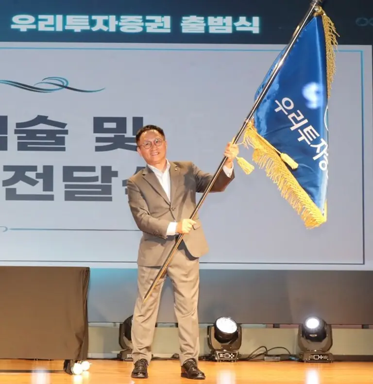 남기천 우리투자증권 초대 대표가 1일 우리투자증권 출범식에서 우리투자증권 사기를 건네 받았다. [출처: 우리투자증권]