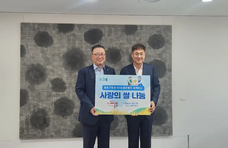 고주영 NH농협은행 종로금융센터장(사진 왼쪽)이 정문헌 종로구청장(사진 오른쪽)에게 쌀을 전달하고 기념 촬영하고 있다. 