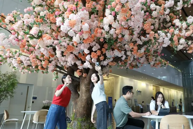 GS건설 직원들이 점심시간을 이용해 동료들과 로비에 설치된 자이목에서 사진을 찍고 있다. (사진제공. GS건설)