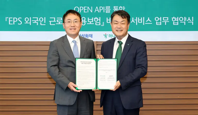 하나은행은 지난 11일 서울 중구 을지로 본점에서 국내 최초로 삼성화재와 EPS(외국인 고용허가제) 외국인 근로자 전용보험 서비스를 위한 업무 협약을 체결했다. 이날 협약식에 참석한 최재봉 삼성화재 일반보험부문장(왼쪽)과 성영수 하나은행 기업그룹 부행장이 협약서를 들고 기념사진을 촬영했다. [출처: 하나은행]