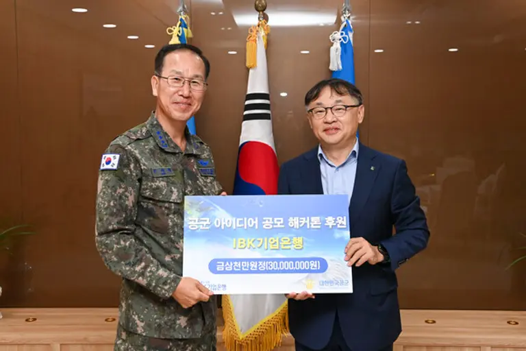 유일광 IBK기업은행 개인고객그룹 부행장(오른쪽)이 지난 24일 충남 계룡시 공군본부에서 손석락 공군참모차장 중장에게 제6회 공군 해커톤 행사 후원금을 전달했다. [출처: IBK기업은행]