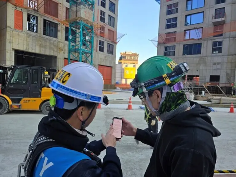 DL이앤씨 직원이 수도권의 한 아파트 건설 현장에서 외국인 노동자에게 ‘AI 자동번역 시스템’을 안내하고 있다. (사진제공=DL이앤씨)