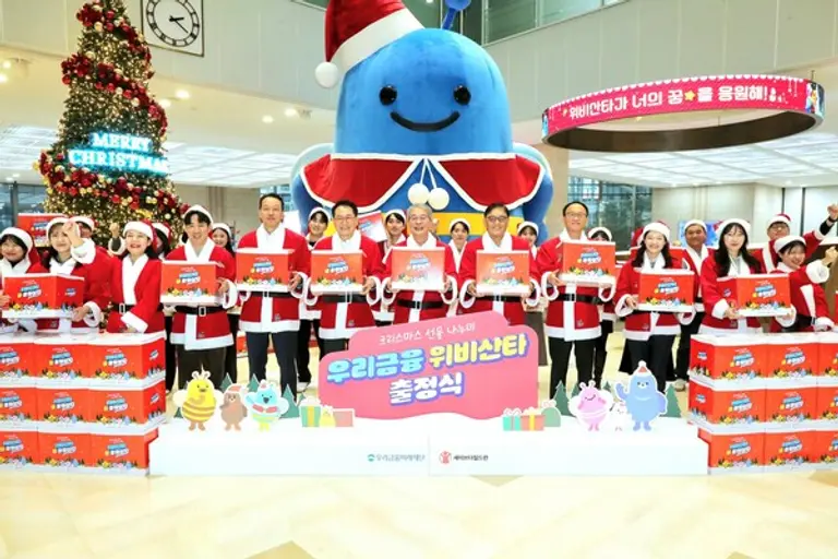 임종룡 우리금융그룹 회장(오른쪽 여섯 번째)과 정태영 세이브더칠드런 총장(오른쪽 다섯 번째)이 지난 16일 서울 중구 우리은행 회현동 본점에서 우리금융그룹 임직원과 함께 위비산타 출정식에서 ‘우리미래 꿈 응원 상자’를 들고 기념 촬영을 했다. [출처: 우리금융그룹]