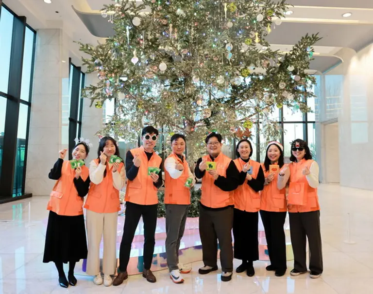 한화생명 임직원 봉사단이 지난 23일 서울 여의도 63빌딩 한화생명 본사 로비에 세워진 크리스마스 트리 앞에서 내년 사회공헌 활동 참여를 다짐했다. [출처: 한화생명]